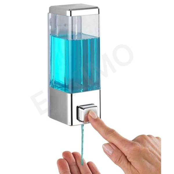 A person pressing the button on a wall-mounted soap dispenser to get soap.